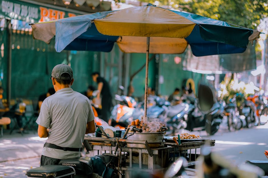 A street vendor prepares food at a busy outdoor market in Ho Chi Minh City