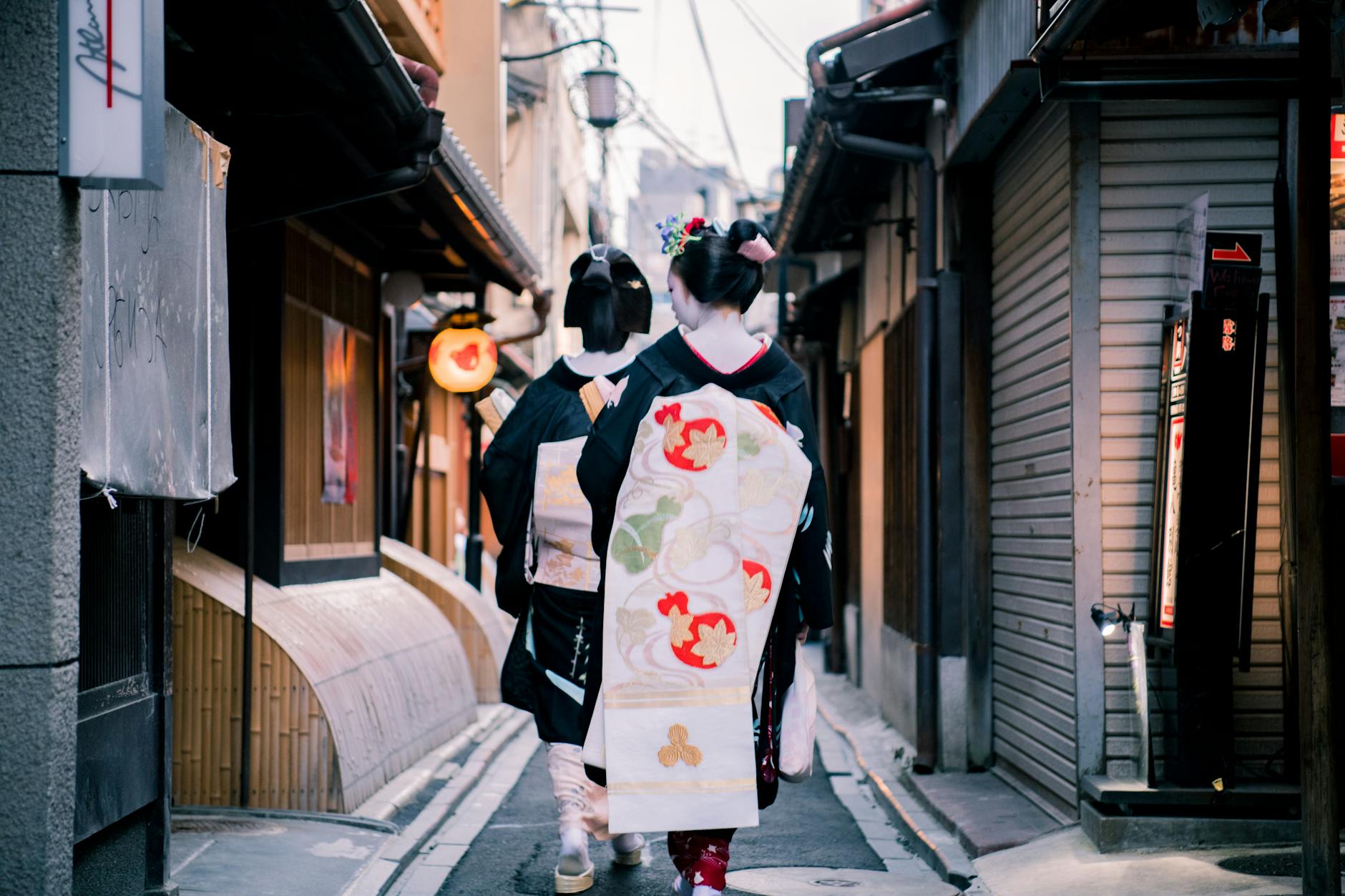 People wearing traditional kimonos walking through a historic Kyoto street