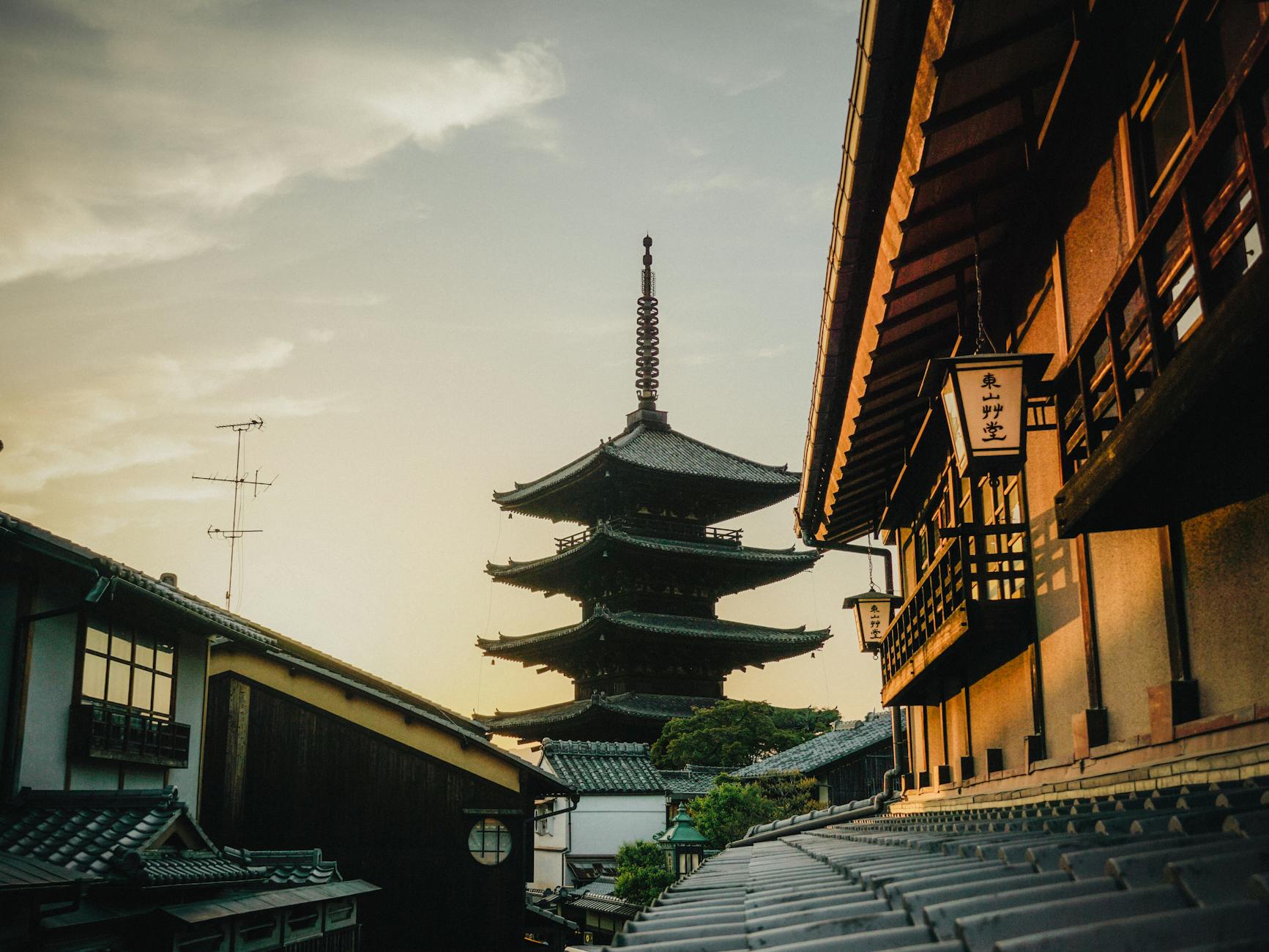 Traditional Japanese pagoda silhouetted against a warm sunset sky in Kyoto