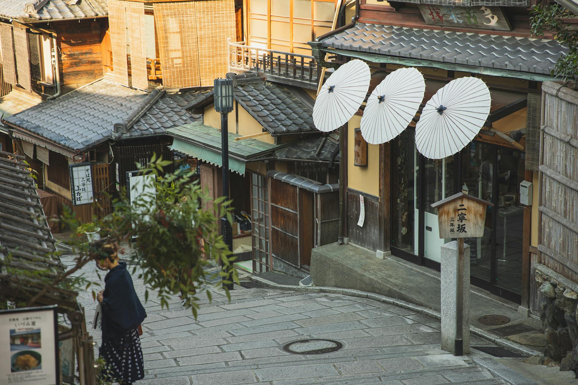 Traditional wooden machiya houses lining a stone-paved street in Kyoto's Higashiyama district
