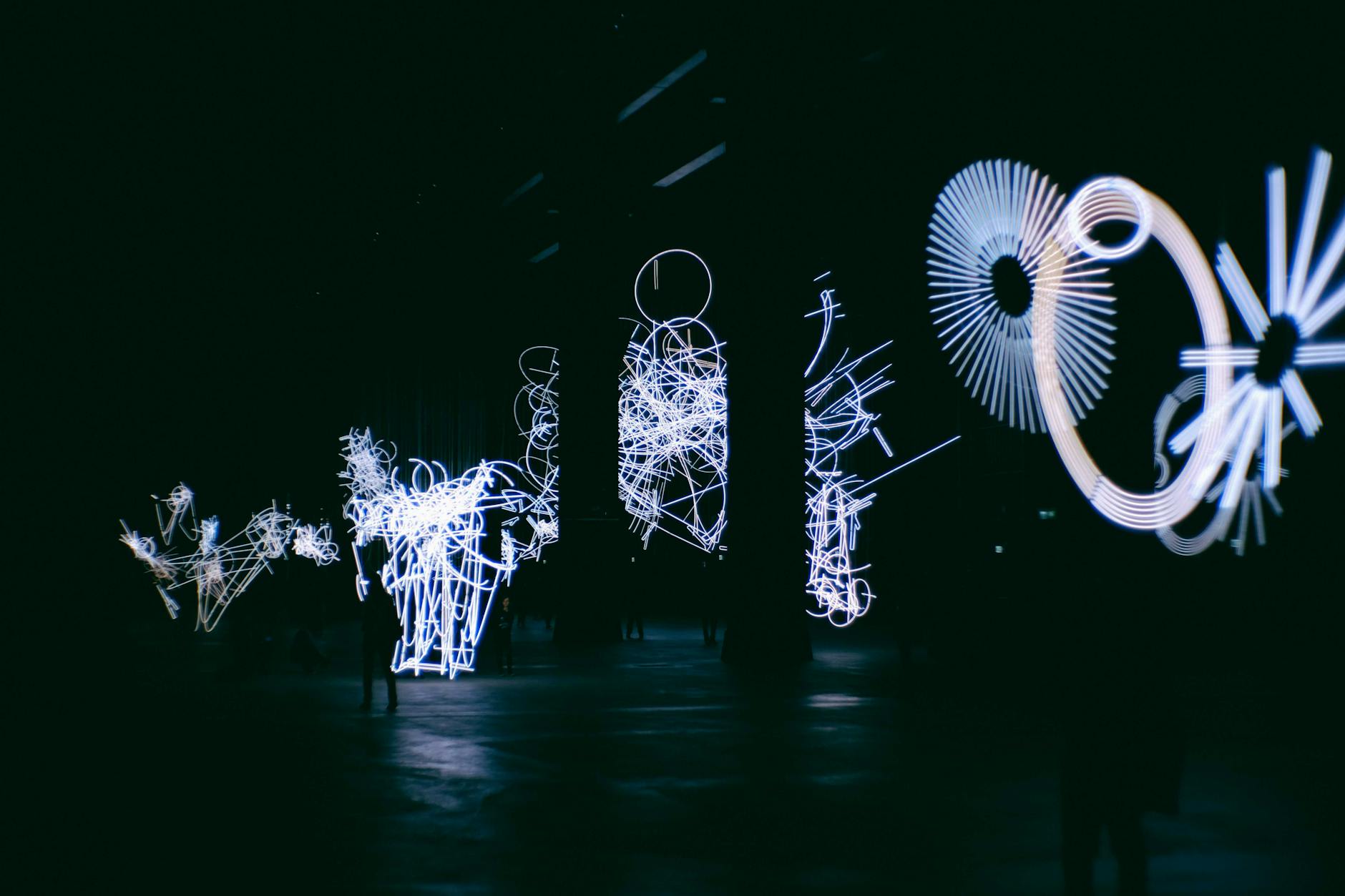 Immersive digital art installation with colourful lights reflected on water