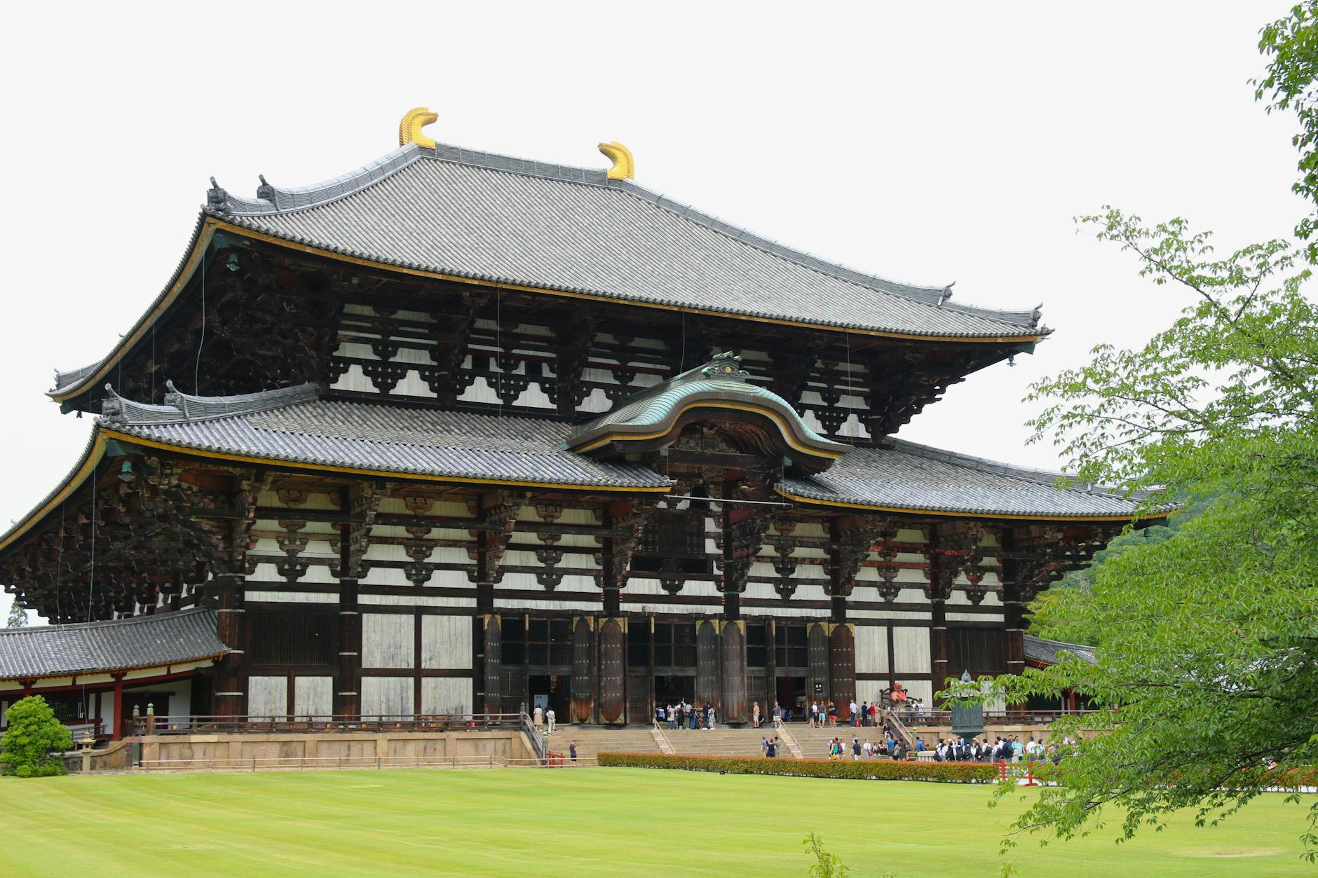 Todai-ji temple's massive wooden gate with visitors walking through in Nara
