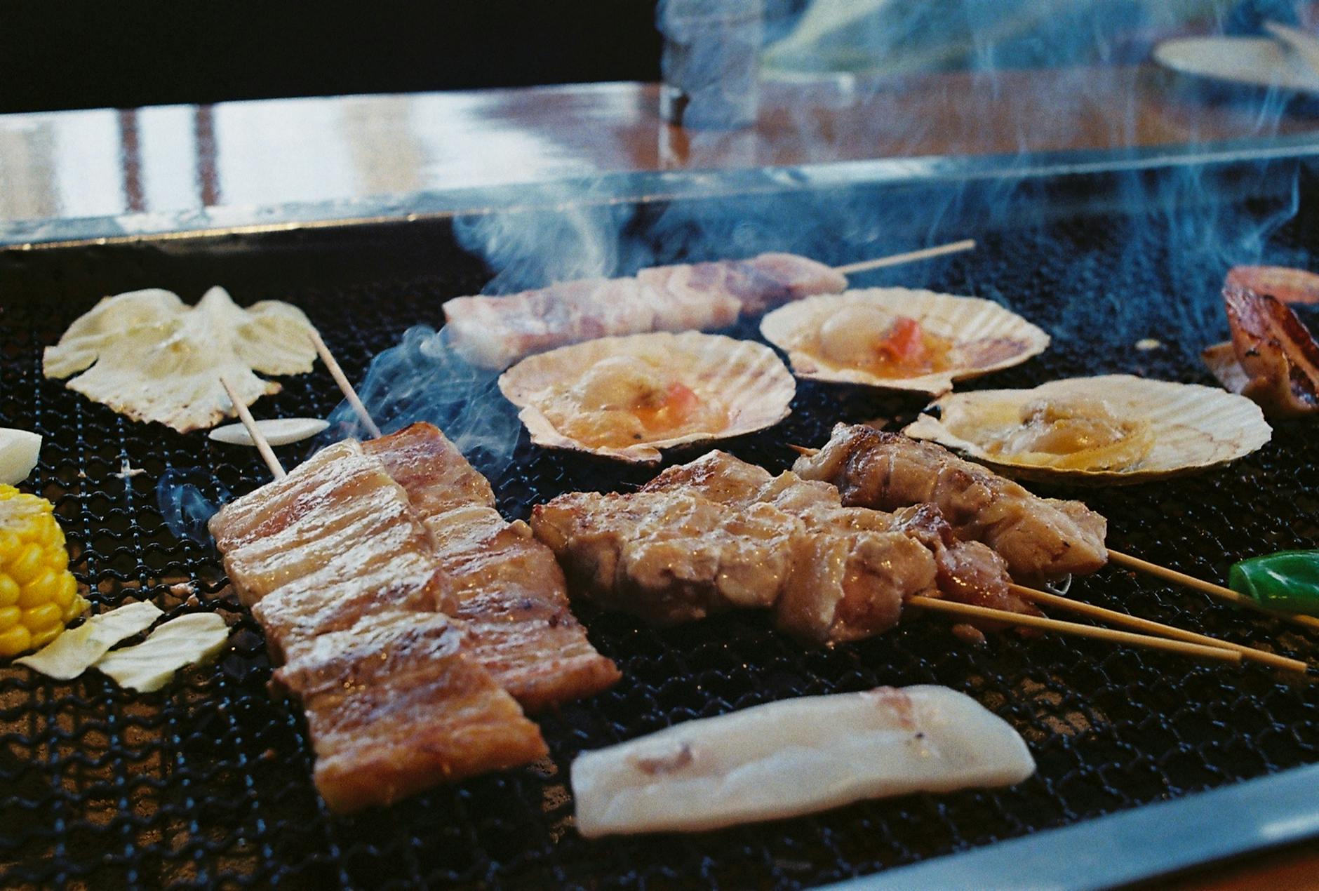 Sizzling yakitori skewers on a charcoal grill at a Japanese izakaya