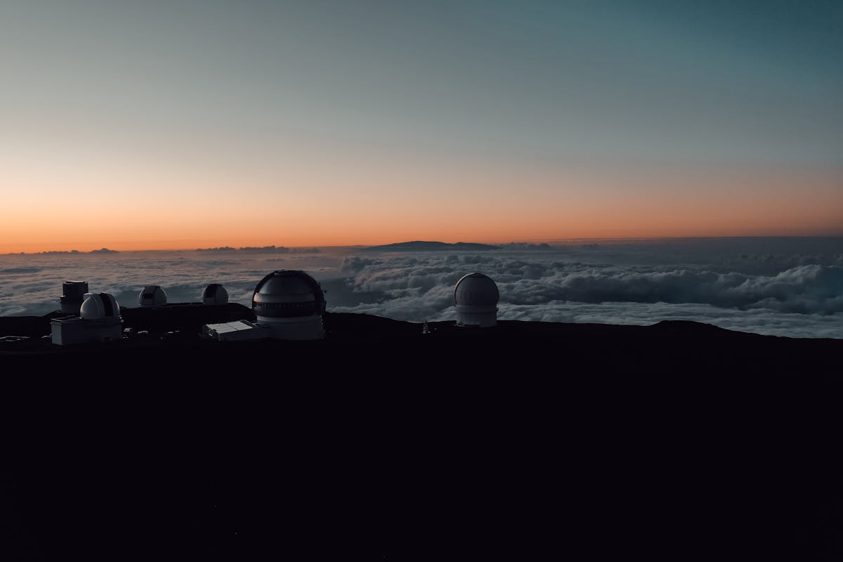 The summit of Mauna Kea above the clouds at twilight