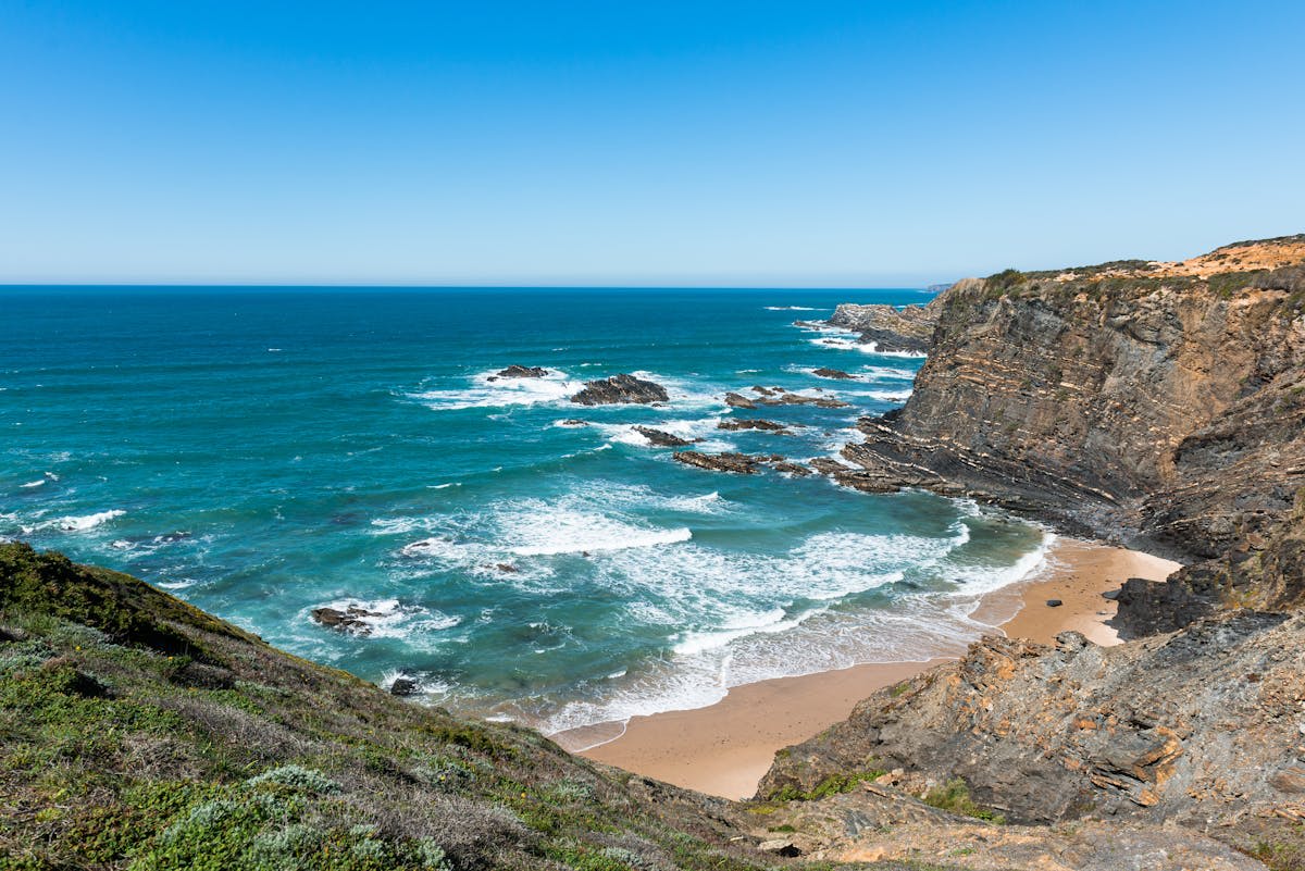 Dramatic coastal cliffs along the Alentejo shoreline at golden hour