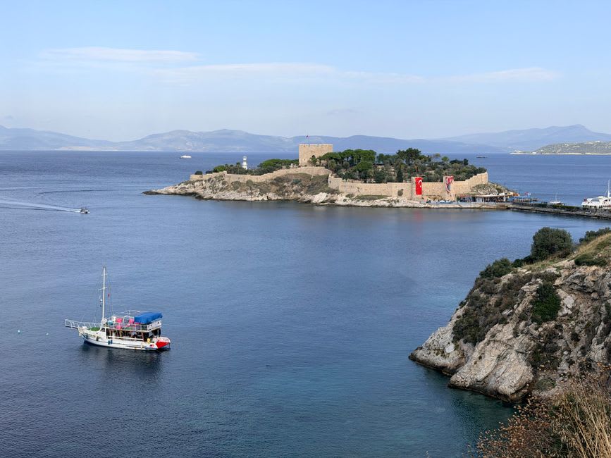 La calzada de piedra que conduce a la pequeña isla fortificada de Güvercinada en el puerto de Kuşadası al atardecer