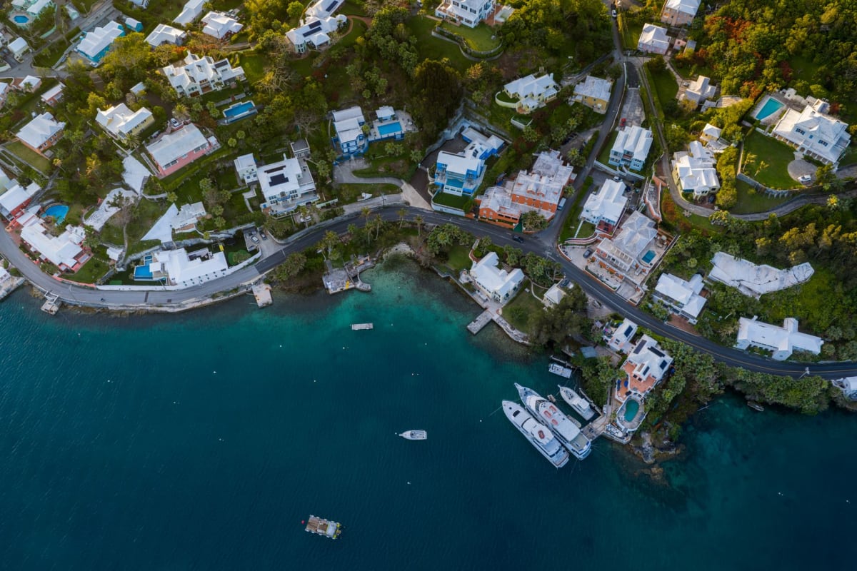 Veleros amarrados en la marina de English Harbour con las verdes colinas de Antigua al fondo al atardecer