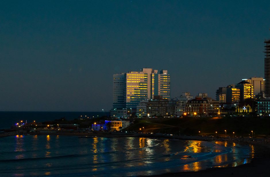 The grand Rambla boardwalk and Casino Central building overlooking a crowded beach in Mar del Plata