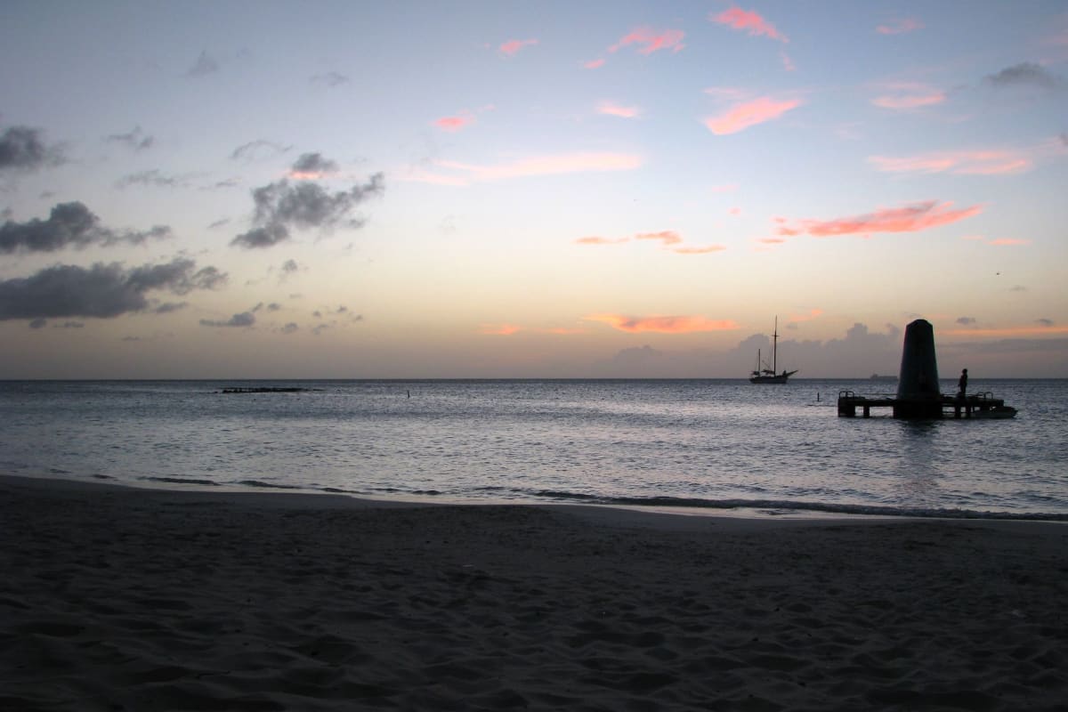 Palm Beach sunset with the Caribbean turning deep orange and silhouetted figures on the shoreline