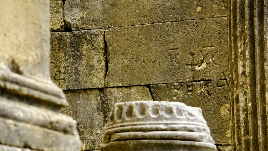 Merchant cells lining the courtyard walls at Ateshgah, with stone inscriptions visible near the doorways
