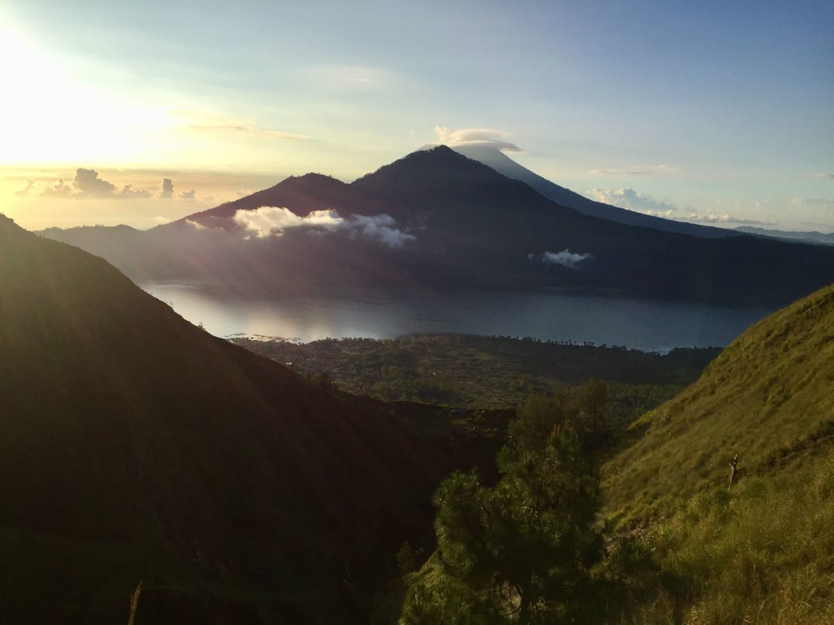 Fumerolles au sommet du mont Batur contre le ciel du petit matin, le lac Batur et la caldeira s'étendant loin en contrebas