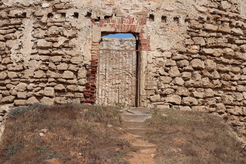 Ruined red-brick medieval castle towers of Novogrudok Castle rising above green hillside