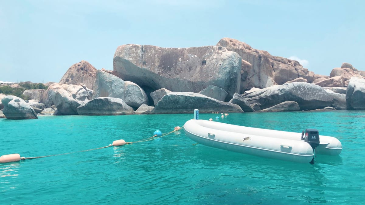 Massive granite boulders at The Baths forming natural sea pools and grottos at dawn, warm light filtering through the gaps