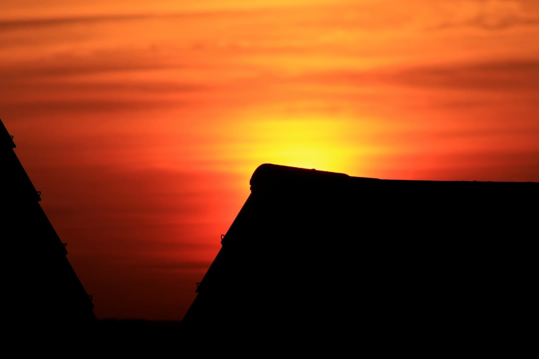Une maison en banco reconstruite avec un toit en tôle neuf en périphérie de Kaga-Bandoro au coucher du soleil