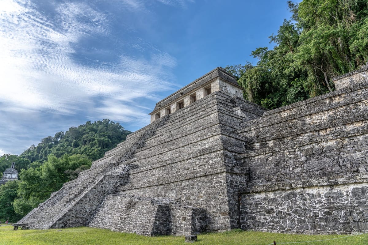 Friso de piedra en Toniná mostrando cautivos atados y figuras guerreras, fino tallado del Clásico Maya