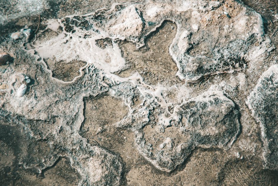 Una cascada más pequeña en el cañón superior de Ma'in, depósitos minerales acumulados en crestas pálidas a lo largo de la roca