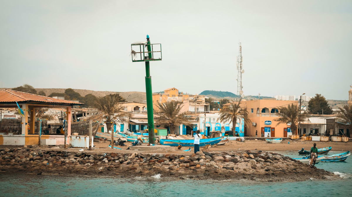 Des collines volcaniques noires plongeant vers l'eau sombre et presque immobile de la baie de Goubet al-Kharab