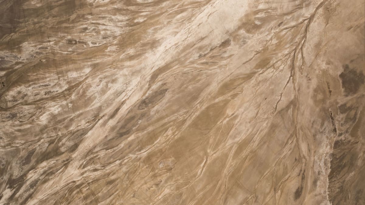 La rive cristalline de sel du lac Assal à l'aube, craquelée en motifs géométriques