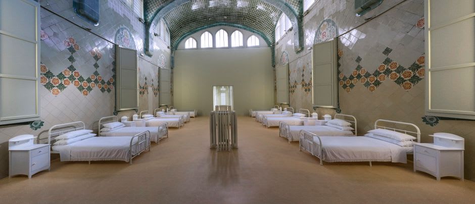 La Grande Salle des Pauvres voûtée à l'intérieur de l'Hôtel-Dieu de Beaune, bordée de lits d'hôpital médiévaux à baldaquin