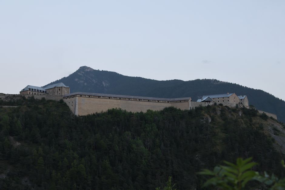Les remparts de pierre en étoile de Vauban autour de la vieille ville de la Cité Vauban à Briançon au crépuscule, montagnes en arrière-plan