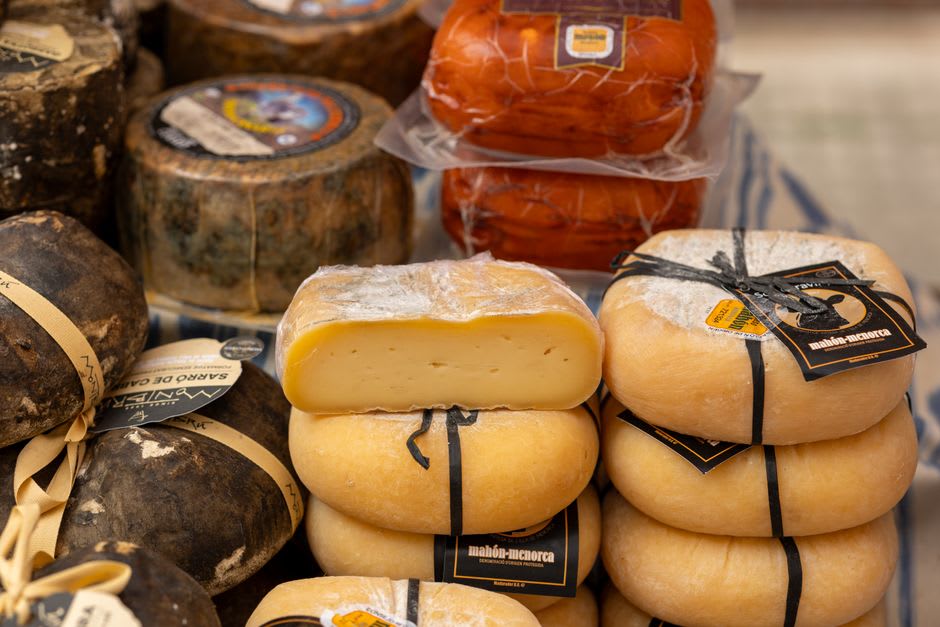 Du pain et une meule de Tomme alpine exposés sur un étal de marché dans la Cité Vauban de Briançon