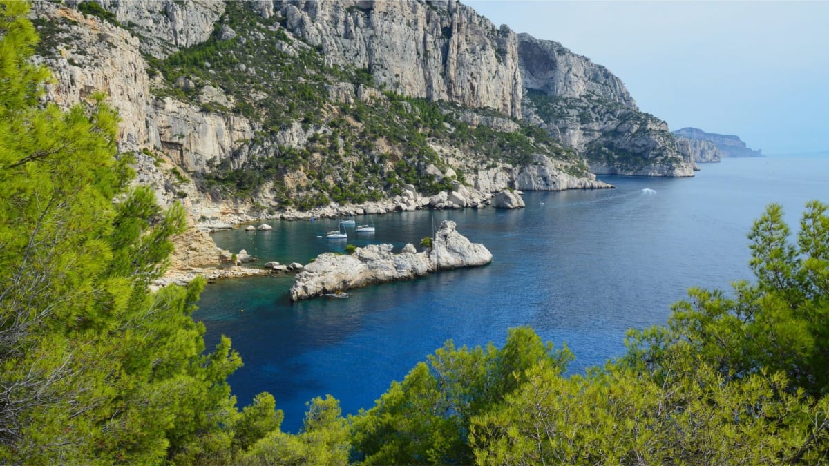 Le littoral sauvage sous les Calanques de Piana, eau turquoise et roche rouge se rencontrant dans une petite crique cachée