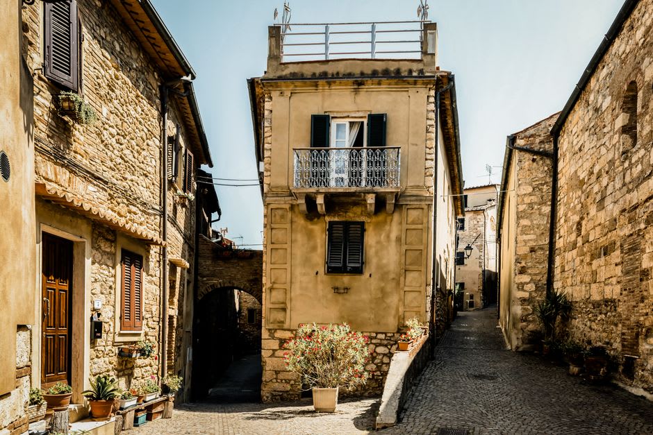 Une étroite rue à arcades du vieux quartier de Dole, façades de pierre ocre et volets suspendus