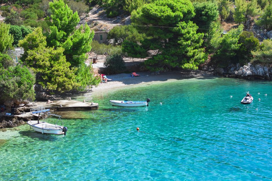 Une crique de sable tranquille près du Lavandou, des pins le long du rivage et une eau turquoise limpide