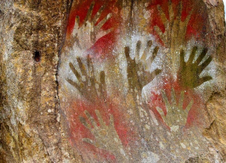 Une chambre de grotte préhistorique faiblement éclairée près des Eyzies, avec une figure de bison ocre visible sur la paroi rocheuse