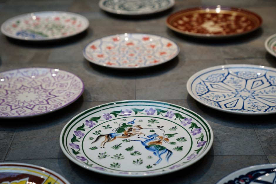 Platos de loza floral pintados a mano expuestos en un taller cerámico de Lunéville