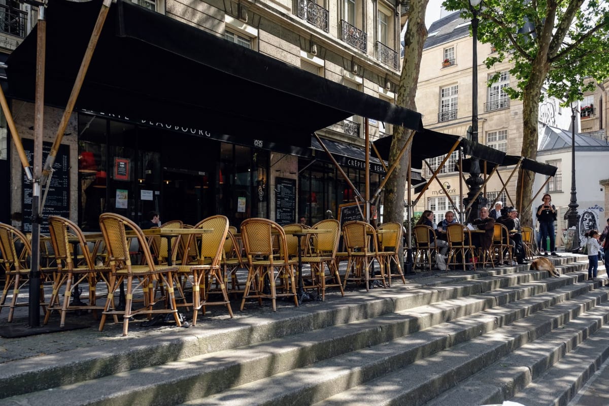 A quiet Paris café terrace with chairs facing the street