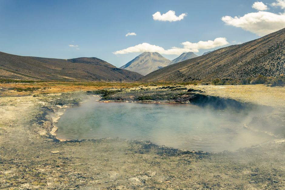 De la vapeur s'élevant d'un bassin thermal extérieur aux Thermes de Saint-Gervais, installé dans une gorge rocheuse dominée par les montagnes
