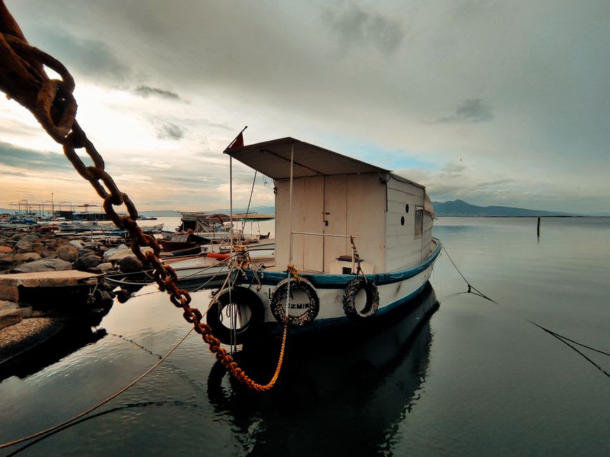 Barques de pêche et petites embarcations amarrées le long du quai de Solenzara avec l'embouchure du fleuve s'ouvrant sur la mer