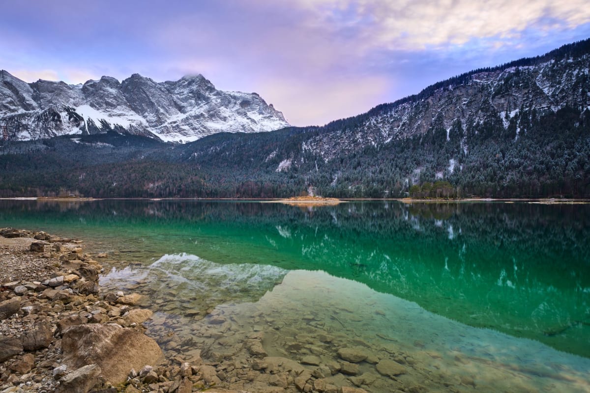 Un lago alpino de aguas cristalinas que refleja los picos bávaros cubiertos de nieve