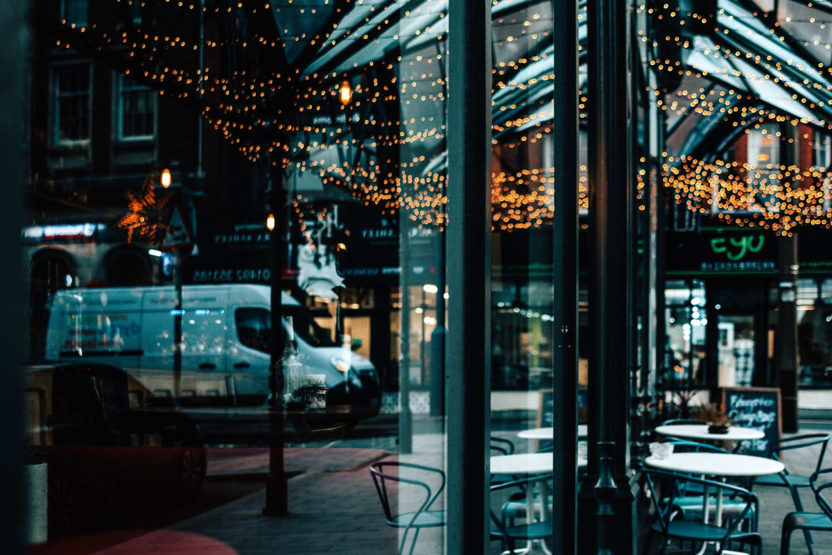 Athens street scene with outdoor taverna tables and string lights at dusk