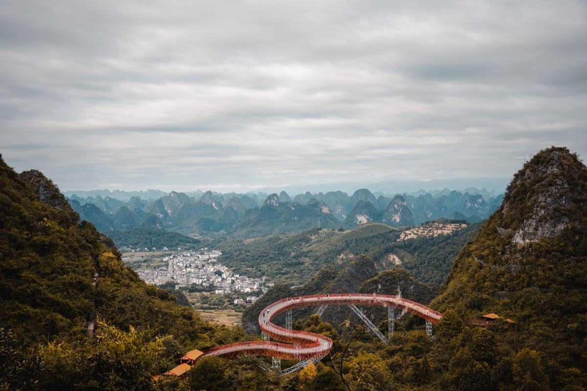 Vista a través del arco de la Colina de la Luna mirando hacia el valle kárstico de Yangshuo, arrozales y el río Yulong visibles a través de la apertura circular