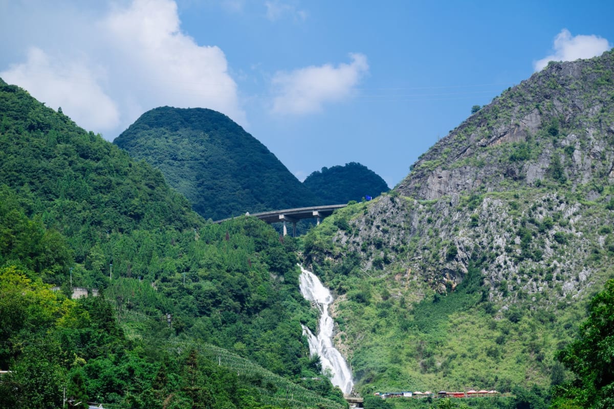 Sentier le long des gorges karstiques sous Huangguoshu, avec de plus petites cascades visibles à travers la forêt