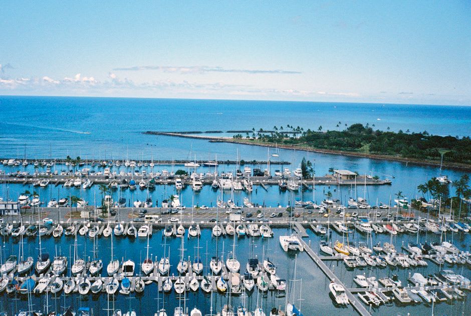 Des lignes de pêche lancées depuis les rochers de Kaumalapau Harbor tandis que le soleil se couche sur l'océan