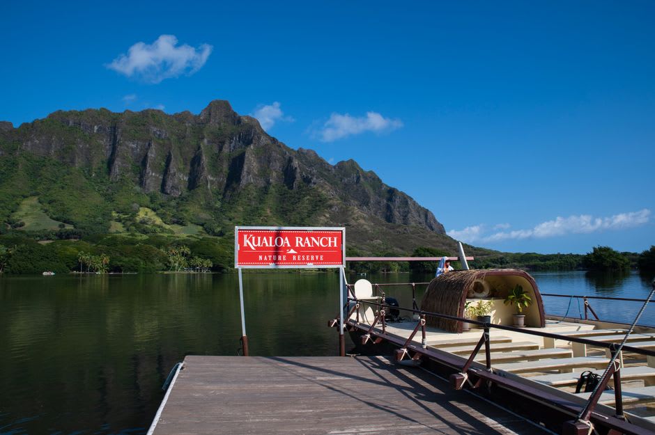 Open-air tour vehicle driving through the jungle valley at Kualoa Ranch