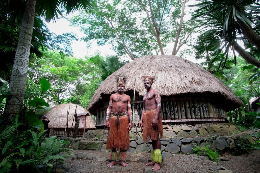 Carved wooden ki'i guardian figures standing before the reconstructed Hale o Keawe temple