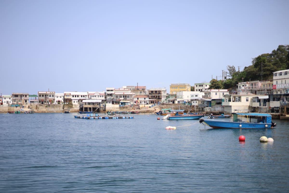 El embarcadero del ferry de Cheung Chau con barcos de pesca y pequeñas embarcaciones de madera amarrados en el puerto tranquilo de la mañana
