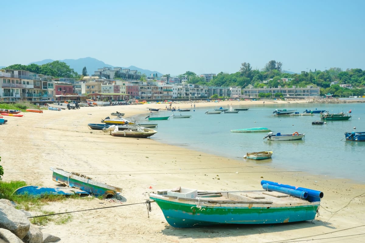 Una callejuela serpenteante en el pueblo de Cheung Chau, ropa tendida entre las casas, una puerta de templo visible al fondo