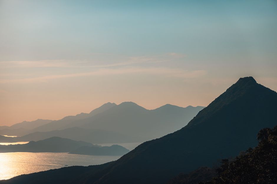 Ruines de huttes de pierre abandonnées éparpillées sur la pente herbeuse ouverte de Sunset Peak sur l'île de Lantau