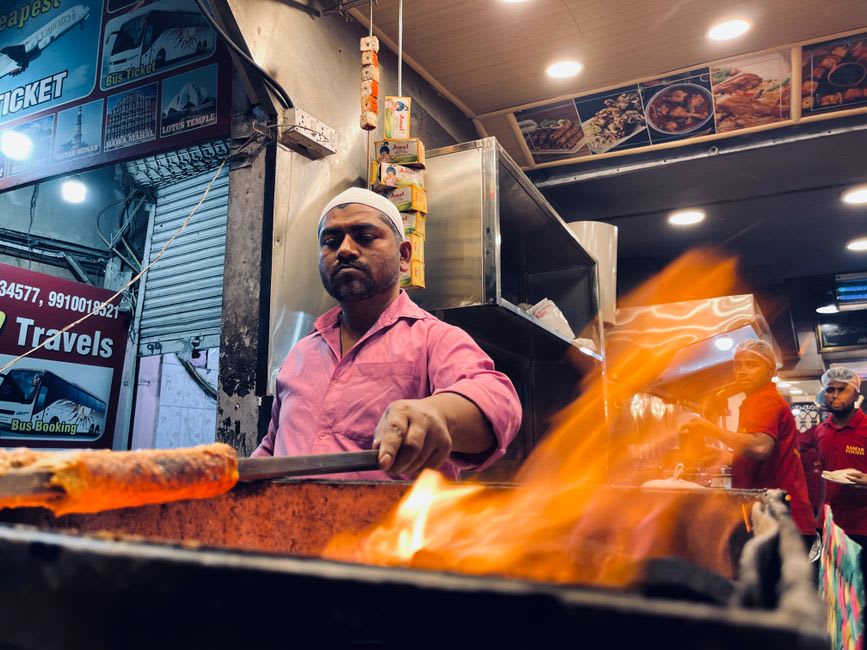 A vendor serving galouti kebabs and warqi paratha at a street stall in old Lucknow