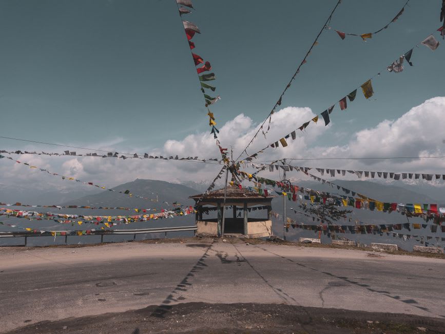 The whitewashed walls of Tawang Monastery with prayer flags strung across the courtyard