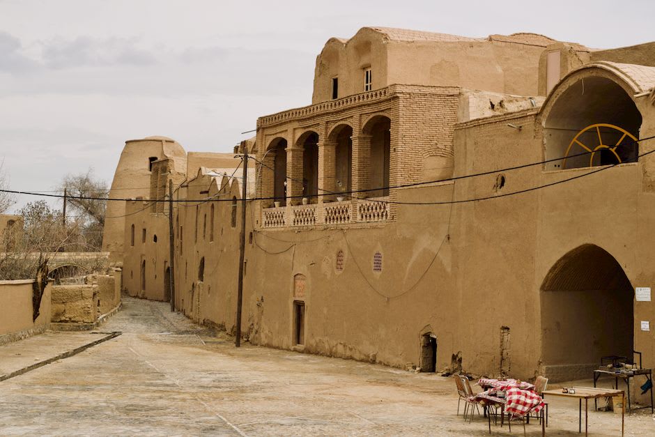 A narrow stone staircase descending into the underground qanat beneath Sar Yazd Castle