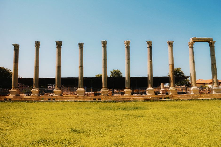 Fallen Roman columns lying in green grass at Ashkelon National Park near the coast
