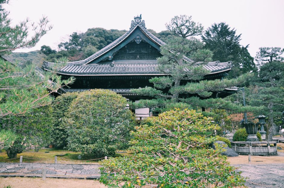 Reconstructed Edo-era buildings and gardens at Date's historical village in southern Hokkaidō, wooden walls and raked paths under a warm sky