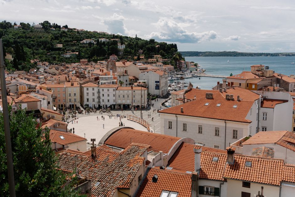 Vue sur le port d'Esashi et l'ancien quartier des marchands depuis un belvédère côtier, bateaux de pêche ancrés sous un ciel gris
