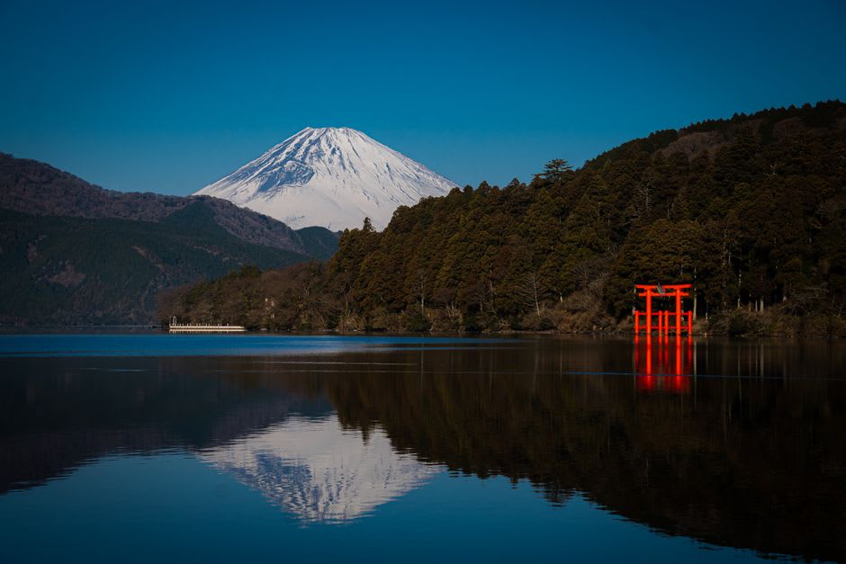 Haruna Shrine's hall built against a towering leaning rock among cedar trees